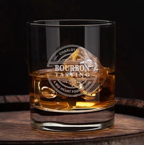 Glass of bourbon on an oak barrel